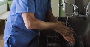 foto de médico lavando as mãos em ambiente hospitalar