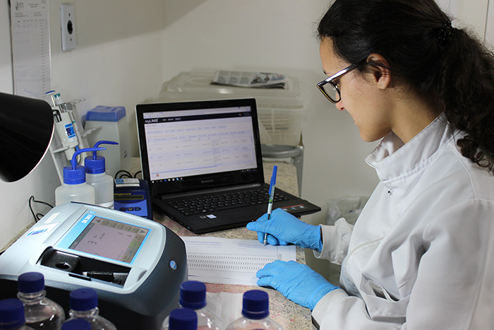 Técnica analisando amostrar de água em laboratório