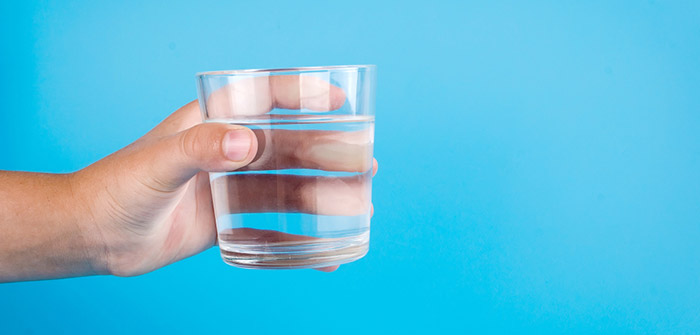 mão segunda copo d'água em fundo azul