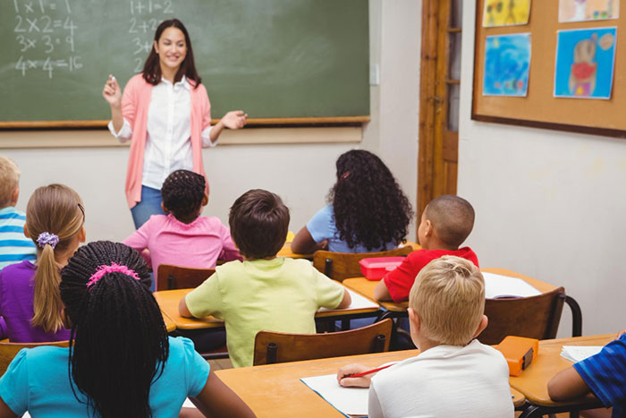 Professora ensinando alunos em sala de aula