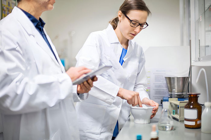 Farmacêuticos manipulando medicamento